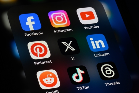 A close-up of various social media applications on a smartphone, including Facebook and Instagram. | The Law Office of Mana Yegani